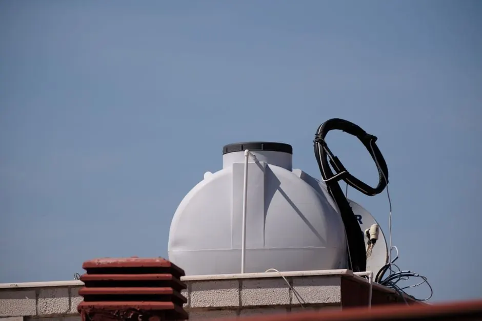 Close-up of a rooftop water tank in Foça, İzmir against a clear blue sky.
